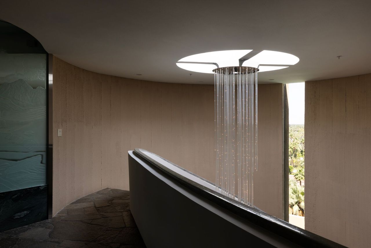 Curved corridor with cascading crystal chandelier and skylight