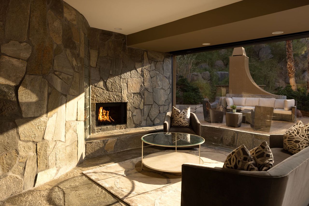 Stone fireplace lounge opening to outdoor terrace