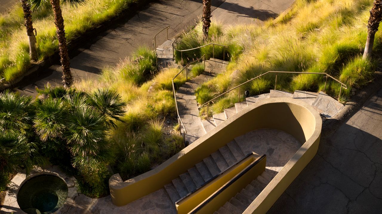 Curved sculptural staircase descending the hillside grounds