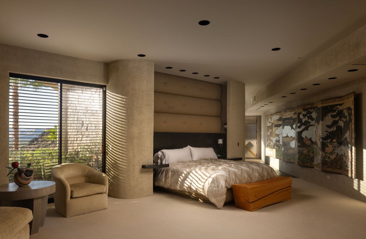 Guesthouse bedroom with upholstered headboard and Japanese screen artwork