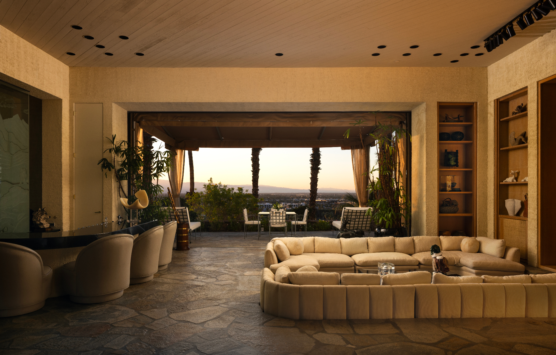 Main residence living room opening to the terrace at sunset